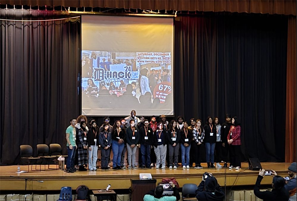 Students standing on stage with the Guest Speaker at D-Hack